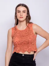Top corto color salmón con estampado abstracto en marrón, sin mangas, con cuello redondo y terminación ondulada en el ruedo.