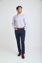 Camisa de vestir blanca de corte clásico, con cuello rígido, cierre frontal de botones y mangas largas con puños abotonados.