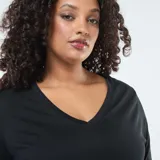 Camiseta de punto negra con cuello en V y mangas largas, de corte recto y holgado.