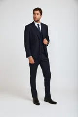 Traje completo de tres piezas en color azul marino, compuesto por saco entallado, chaleco abotonado y pantalón de vestir de corte recto.