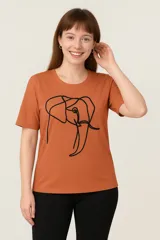 Remera color ladrillo con estampado de un elefante dibujado con una sola línea negra.