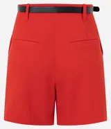 Short sastrero rojo de talle alto, con pinzas delanteras, cierre oculto y bolsillos traseros. Incluye un cinturón delgado de poliuretano.