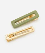 Kit de dos pinzas para el cabello con diseño rectangular calado. Incluye una pinza con acabado en color verde mate y otra en metal dorado, ambas con mecanismo de resorte interno.