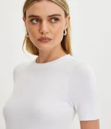 Blusa básica de punto color naranja, con cuello redondo y mangas cortas con barra contrastante.