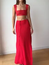 Falda larga tejida color marrón con brillo metálico, corte al cuerpo, abertura alta en la pierna y recortes laterales con cordones ajustables.