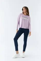 Remera lila de algodón con mangas largas, cuello redondo y estampado frontal con la frase "Every week is fashion week".