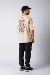 Remera de corte oversize color negro, con cuello redondo y mangas cortas. Presenta una estampa pequeña en el centro del pecho con la frase 'Fresh from the vine' en tipografía blanca.