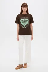 Remera marrón de manga corta y cuello redondo, con estampa frontal en tono verde claro con el texto 'You are my lucky' y motivos gráficos.