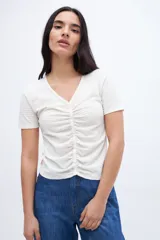 Remera negra con escote en V, cartera de botones, frunces y mangas cortas.