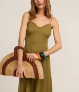 Mono largo color verde oliva, de breteles finos y escote corazón. Presenta recortes en el busto y la cintura, además de pliegues.