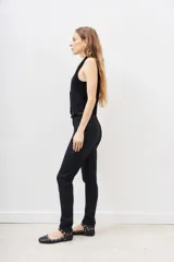Pantalón de jean negro de corte skinny y tiro alto, confeccionado en gabardina con elastano y recubrimiento que simula cuero.