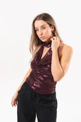Top halter bordó de tela stretch con acabado satinado y brillo, escote drapeado y cuello alto ajustado.