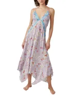 Vestido largo de tirantes finos con estampado floral en tonos lila, rojo y blanco. Presenta escote en V con ribete azul y corte asimétrico en el bajo.