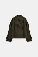 Trench corto Zara Woman Collection confeccionado en hilatura con algodón, en color verde militar. Presenta cuello solapa, manga larga con trabillas y botones en los puños, bolsillos delanteros, bajo asimétrico y cierre frontal cruzado con botones.