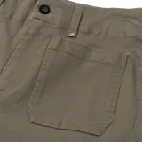 Pantalón de gabardina color verde oliva, de corte ancho y largo a la pantorrilla, con bolsillos delanteros tipo parche.