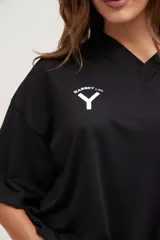 Camiseta negra de manga corta con cuello en V, corte holgado y cordón ajustable en la cintura.