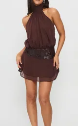 Vestido corto marrón con escote halter fruncido, cintura alta con aplique de lentejuelas y falda con volados en capas.