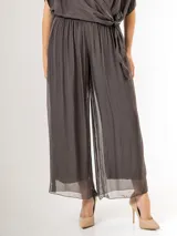 Pantalón de seda italiana con forro de viscosa elastizada, de corte holgado y diseño fluido, con detalles de paillettes en los costados y cintura elastizada.