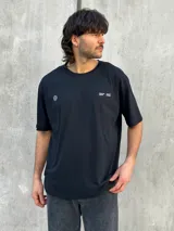 Remera negra oversize con cuello redondo y estampado pequeño en el pecho.