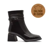 Bota de vestir de caña media confeccionada en cuero negro con acabado brillante. Presenta un diseño de punta cuadrada, taco geométrico ancho y una tira decorativa con hebilla metálica en la parte superior del tobillo.