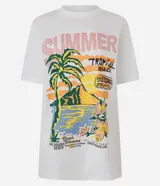 Remera de algodón color blanco, de corte alargado, con cuello redondo y manga corta. Presenta una estampa frontal de estilo tropical con palmeras, flores y texto 'Summer Tropical Beach'.