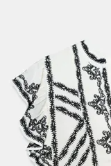 Vestido corto blanco de Zara Woman Collection con bordados en contraste de color negro, escote en V y mangas sisa con pequeños volados.