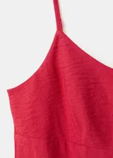 Vestido corto rojo de tirantes finos, con diseño fluido y tejido plisado.