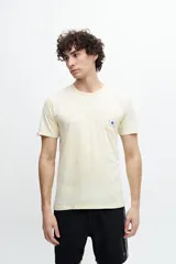 Remera color crema con bolsillo en el pecho con estampado de sol.