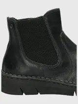 Bota tipo Chelsea de cuero negro, con paneles laterales elásticos y suela de goma flexible con costura vista en el borde.