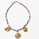 Collar corto con cordón estampado animal print en tonos grises y dijes colgantes dorados en forma de corazón, caracol y concha.