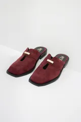 Zuecos de cuero color bordó con punta cuadrada, detalle de abertura en el empeine y aplique metálico dorado.