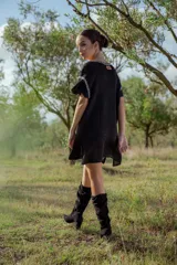 Vestido corto tejido en lurex negro con cuello redondo y mangas cortas.