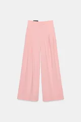 Pantalón ancho de tiro medio, color rosa pálido, con pinzas delanteras y bolsillos laterales y traseros.