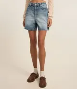 Bermuda de jean celeste con lavado dirty, tiro alto, corte amplio y terminación deshilachada.