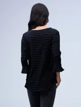 Blusa negra texturada de poliéster y elastano, con mangas 3/4 acampanadas y cuello redondo.