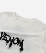 Remera de algodón color blanco, con cuello redondo y manga corta. Presenta una estampa frontal con el logo de Venom en estilo graffiti negro.