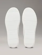 Zapatillas de perfil bajo Calvin Klein confeccionadas en tejido de punto transpirable color blanco. Presentan un diseño minimalista con puntera revestida, suela de goma blanca y detalle de trabilla trasera en piel color negro con el logo de la marca en el lateral y la mediasuela.