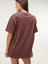 Remera oversize de manga corta color marrón, con cuello redondo y diseño amplio y relajado.
