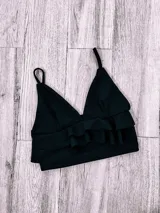 Top color rosa con breteles finos, escote en V y doble volado en el ruedo.