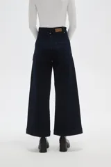 Pantalon de jean azul oscuro de corte ancho y tiro alto, con costuras verticales frontales y bolsillos laterales.