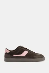 Zapatillas deportivas de estilo urbano, confeccionadas en una combinación de gamuza marrón oscuro y detalles en cuero rosado en el lateral y el talón. Presentan cierre mediante cordones al tono y suela de goma plana.