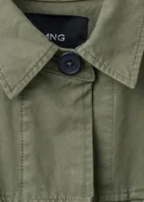 Parka verde militar de algodón, de diseño oversize con cuello camisero, manga larga, bolsillos con solapa en el pecho, bolsillos laterales y cordón ajustable en la cintura.