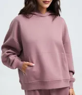 Buzo femenino de corte holgado, color malva, con capucha, manga larga con puños elásticos y bolsillo tipo canguro frontal.