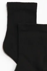 Pack de tres pares de medias negras de punto fino con caña acanalada y elástico superior.
