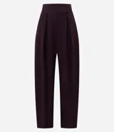 Pantalón de sastrería corte barrel, color marrón oscuro, con pliegues delanteros, cintura con cierre desplazado y piernas anchas.