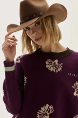 Sweater de punto color bordó con diseño de flores estampadas en tono crema, cuello redondo y puños con detalle de franjas en contraste. Presenta un bordado pequeño en el pecho.