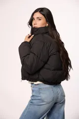 Campera bomber de nylon color negro, con cuello alto, cierre frontal y puños elásticos.