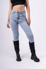 Pantalón de jean celeste de tiro alto, corte ajustado y largo hasta el tobillo.