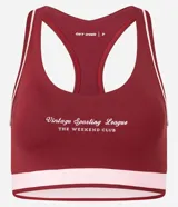 Top deportivo femenino color bordó, modelo copa nadador, con ribetes y banda inferior en rosa claro. Presenta un estampado frontal en blanco con el texto "Vintage Sporting League - The Weekend Club".