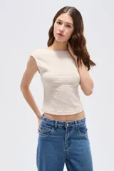 Top cropped sin mangas de poliéster en color negro, con cuello bote y diseño ajustado.